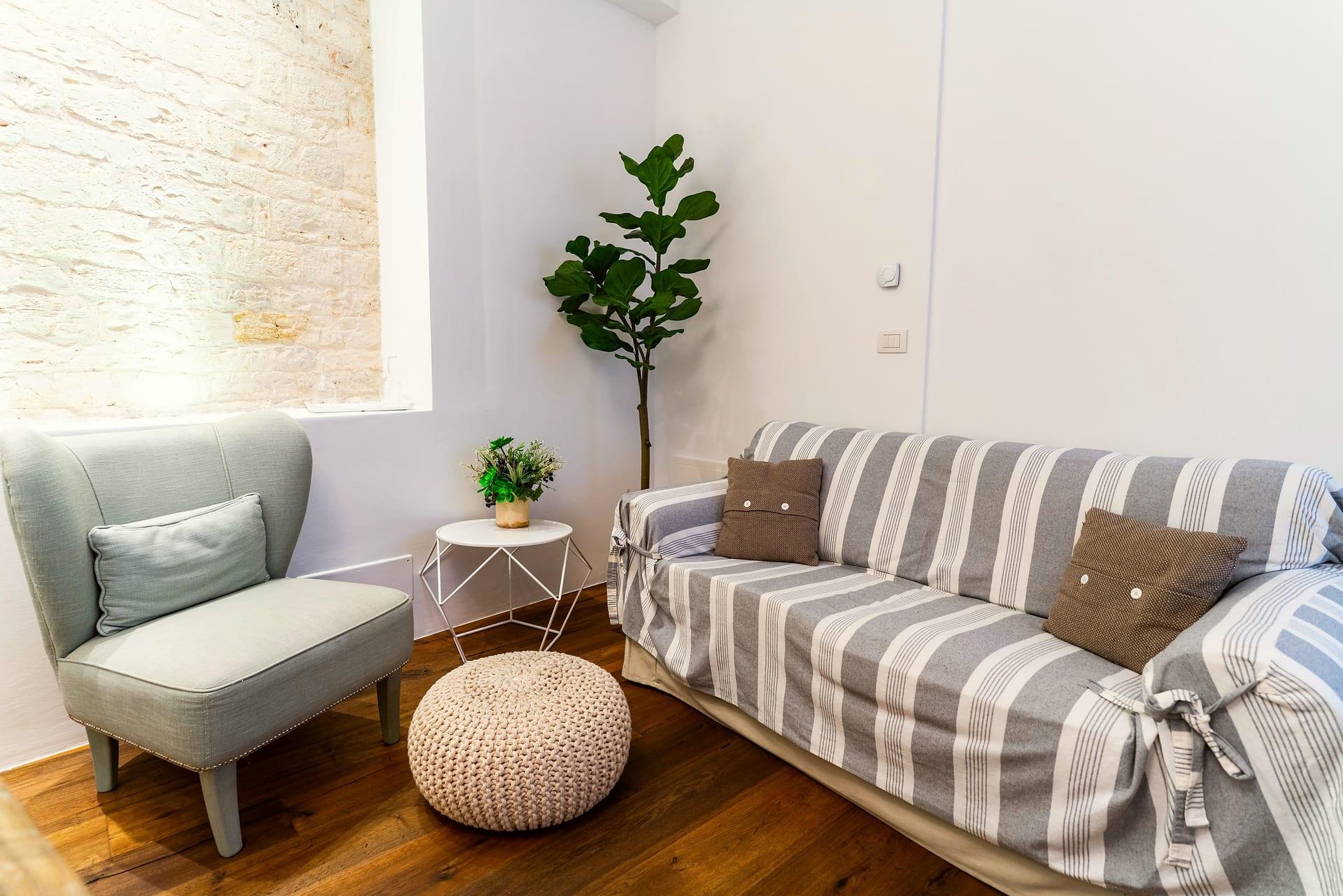 Caminetto — der Strickpouf zwischen Sessel und gestreiftem Sofa, neben dem Tischchen
