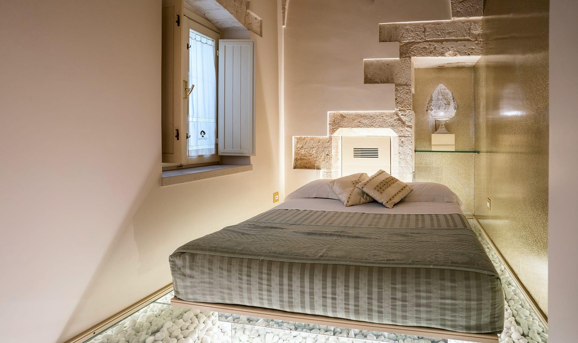 Foresteria — das Bett neben dem Fenster mit weißen Läden und dem bestickten Vorhang