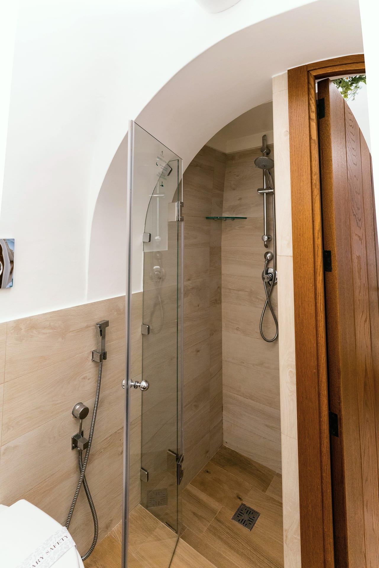 Suite Trullo — die Duschkabine mit Glastür und Fliesen in Holzoptik
