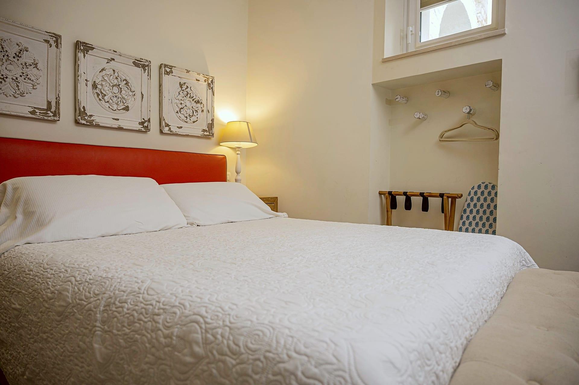 La Piccola — das Bett und die Nische mit Kleiderhaken, Kofferablage und Bügelbrett