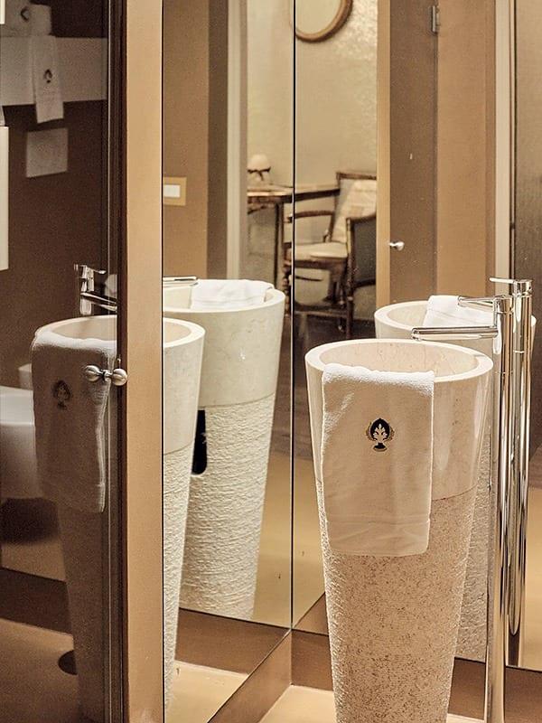 Foresteria — das Säulenwaschbecken aus Stein, vervielfacht von den Badspiegeln