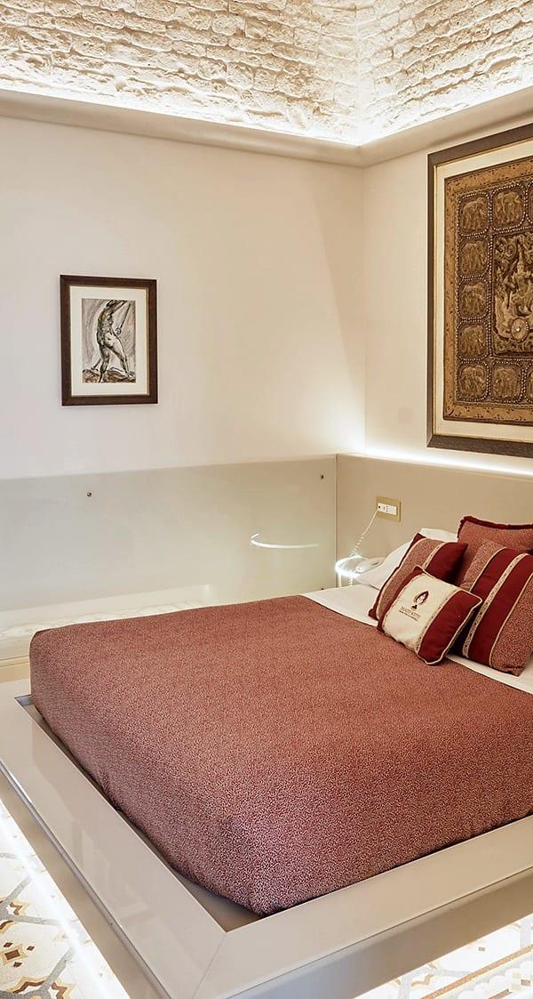 Nobile Deluxe — das Bett auf dem hinterleuchteten Podest, unter dem Steingewölbe