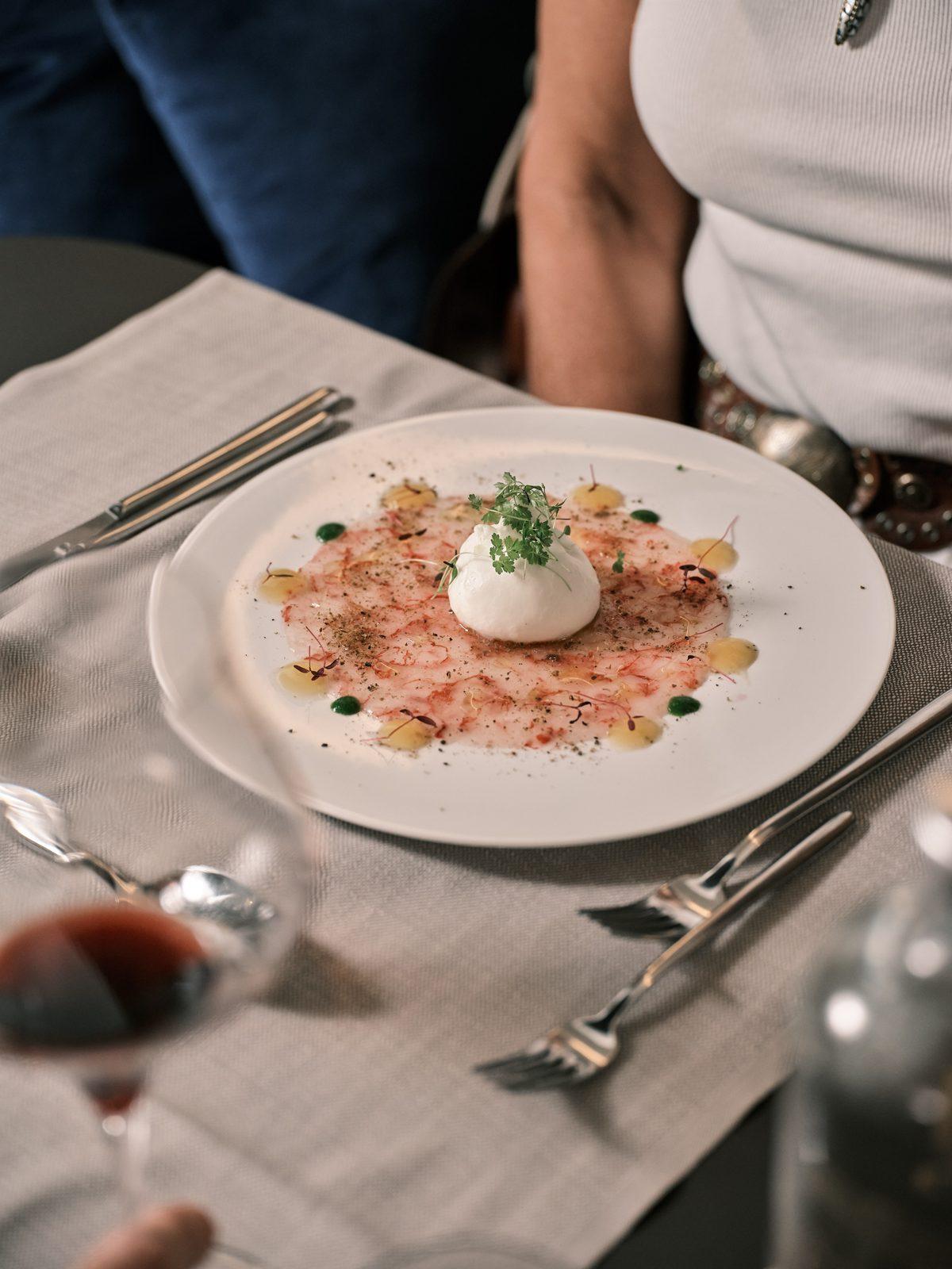 Eine Burrata in der Mitte des Tellers, am Tisch im NOS serviert
