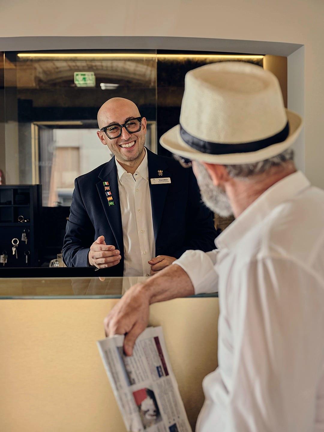 Aan de receptie van het palazzo: een gast en wie hem bij naam noemt