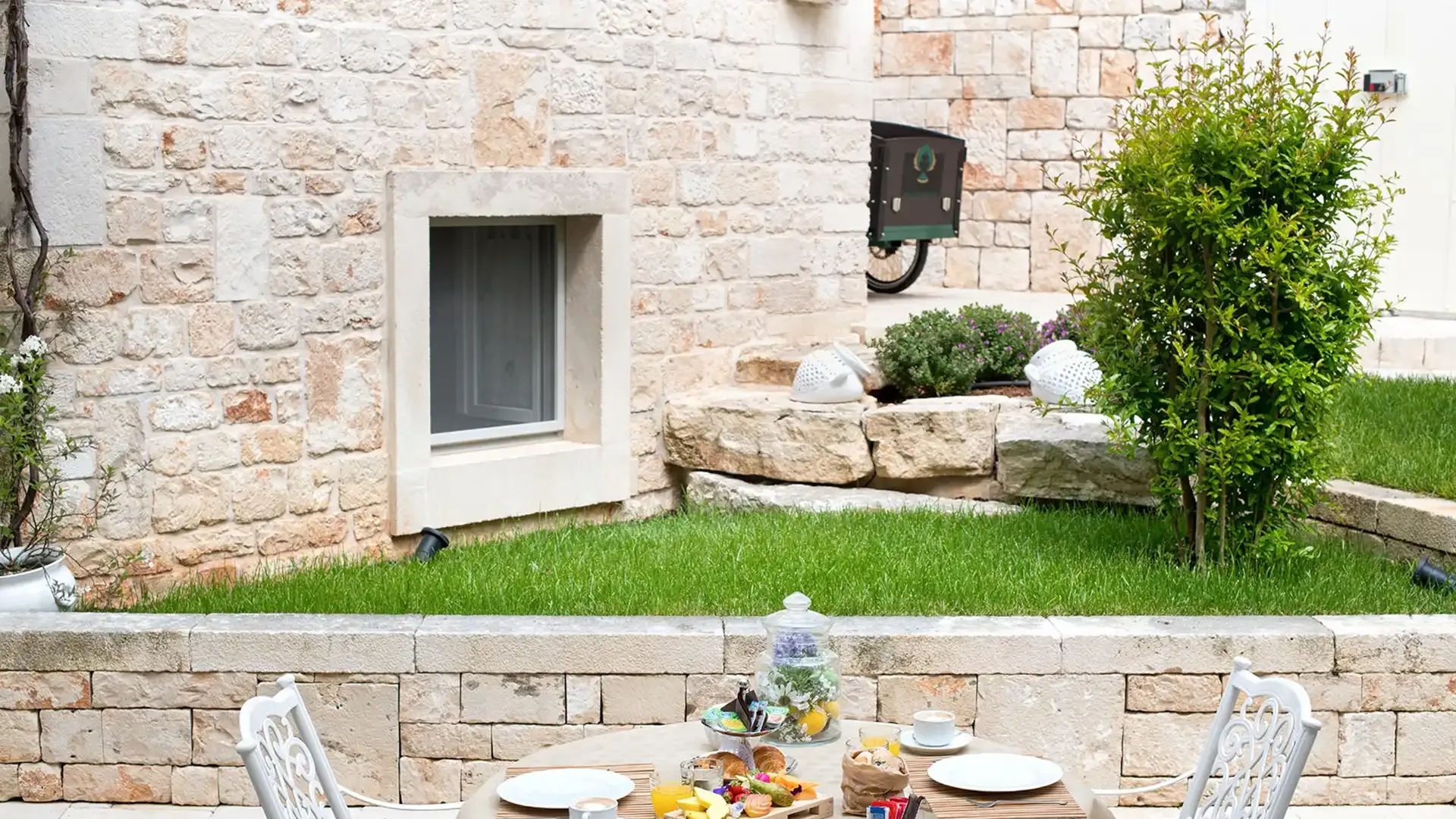 Outdoor breakfast with a set table in a stone garden.