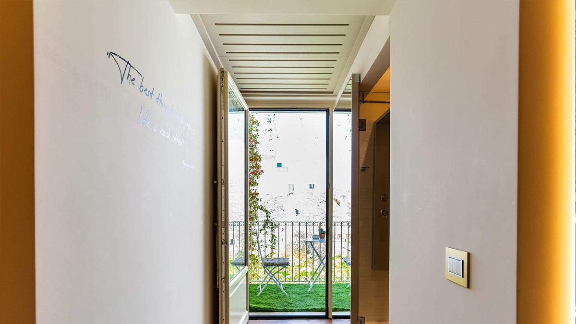 Bright hallway with a view of the balcony and garden.