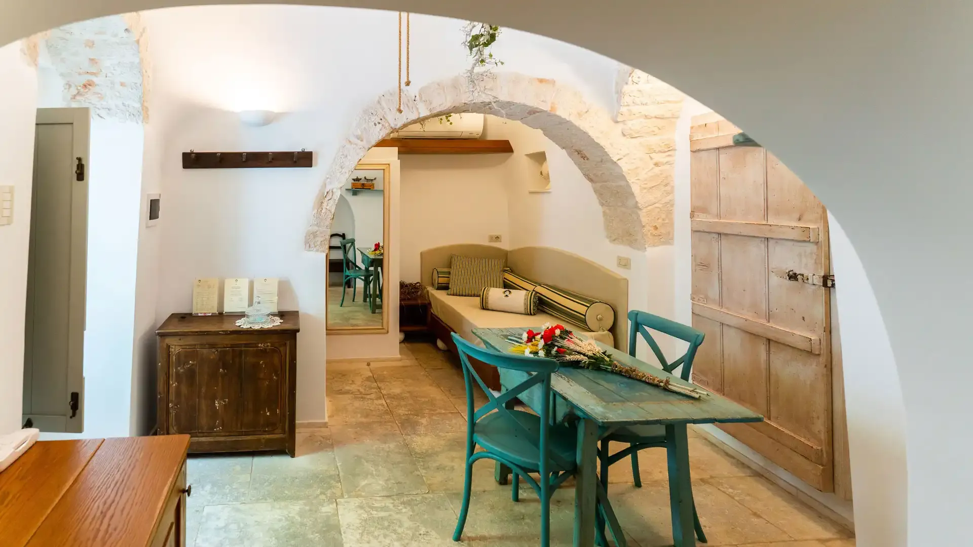 Salon confortable avec des arches en pierre et des meubles rustiques.