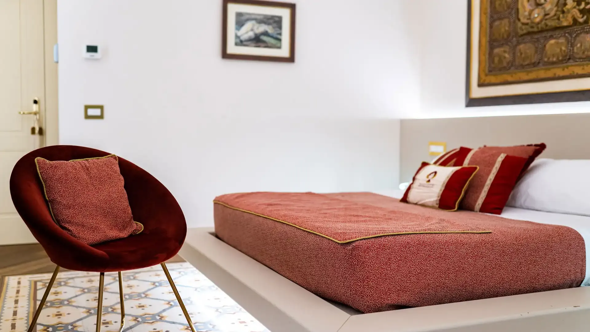 Modern room with floating bed and red chair.