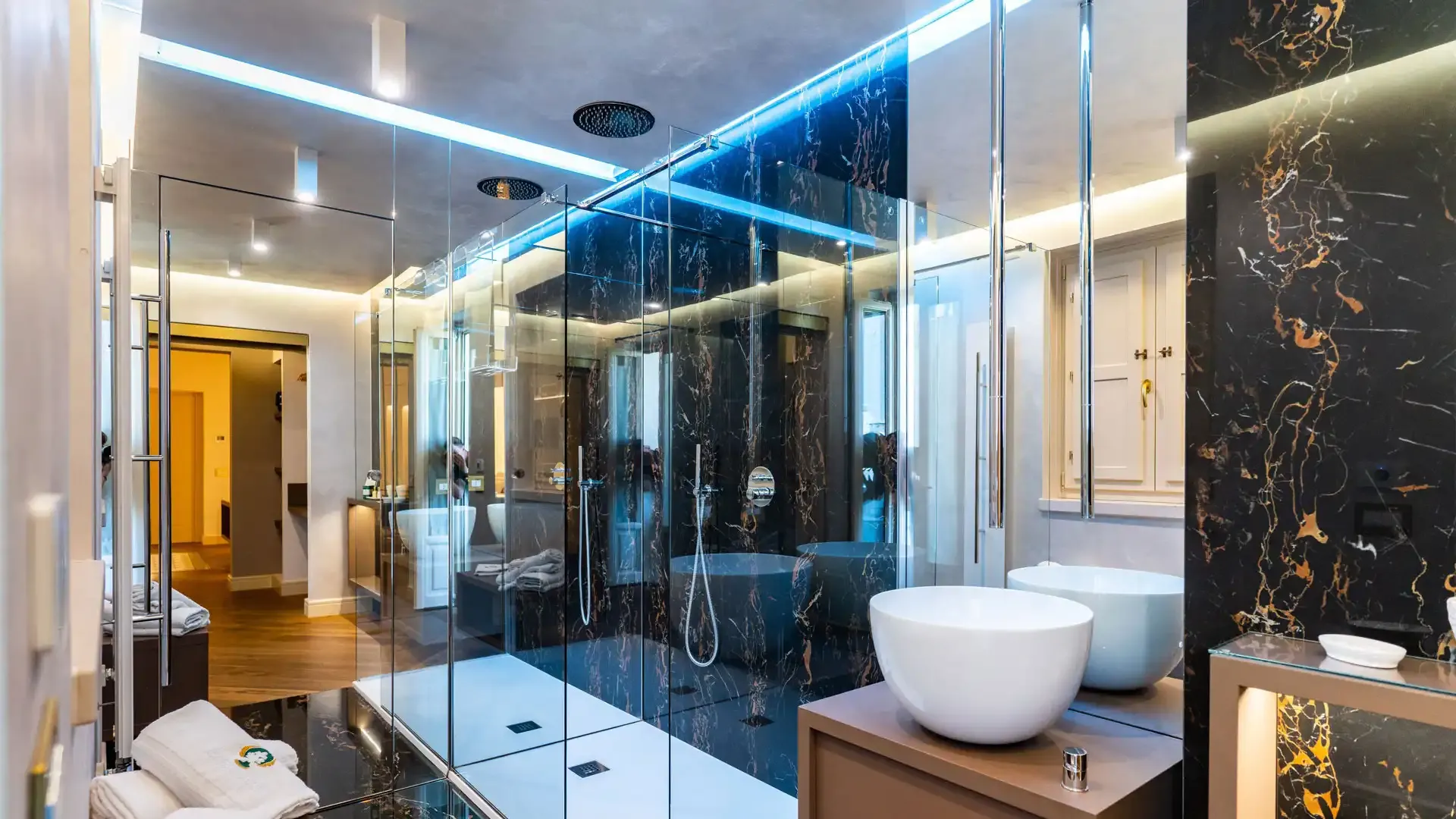 Modern bathroom with glass shower and designer sinks.
