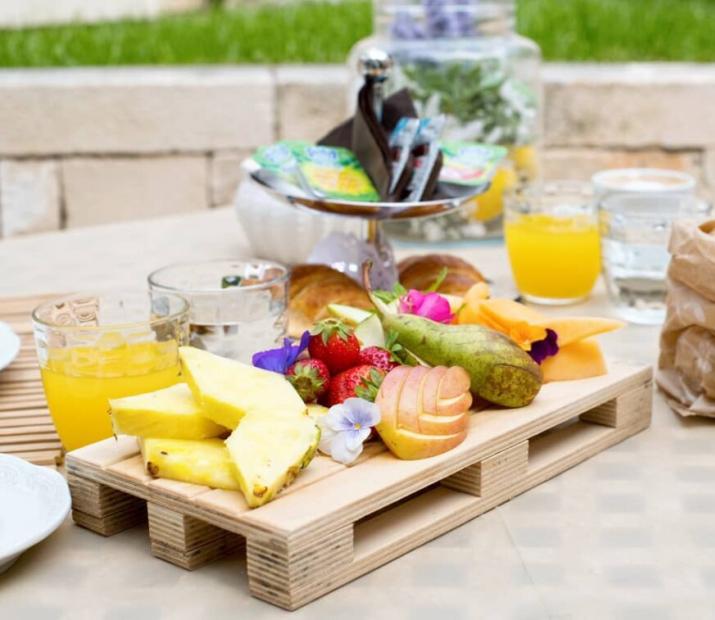 Outdoor breakfast with fresh fruit, juices, and bread.