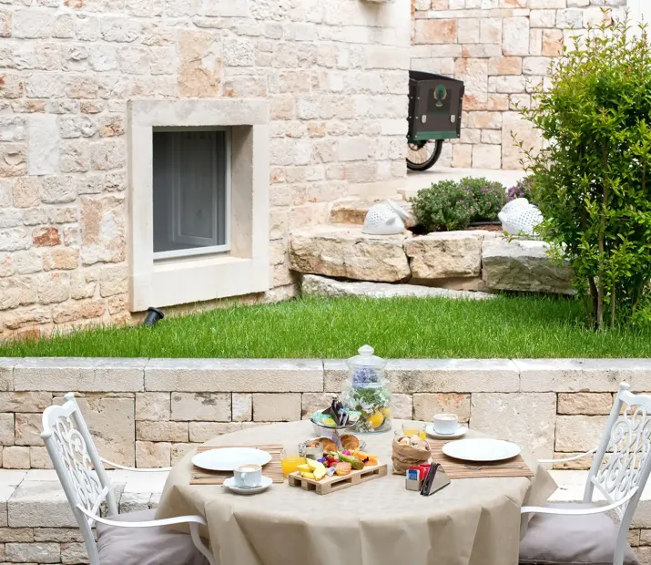 Outdoor breakfast in a stone courtyard with a set table.