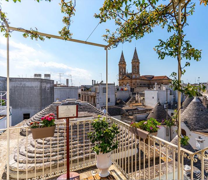 Vue sur les trulli d'Alberobello avec une église en arrière-plan.