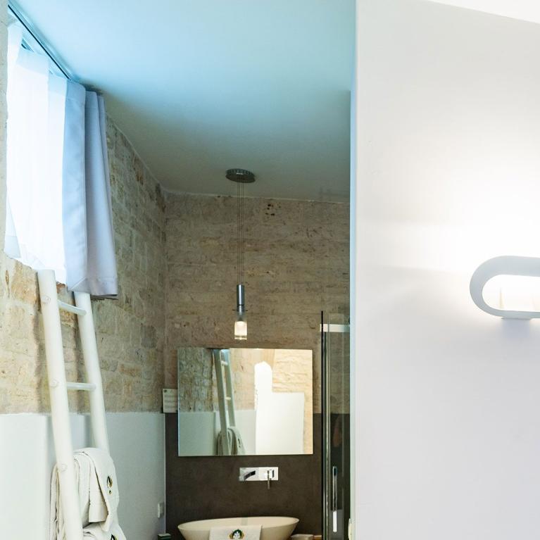 Bagno moderno con lavabo, specchio e scala porta asciugamani.