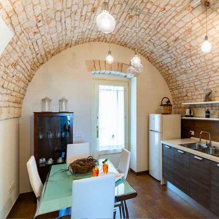 Cucina moderna con soffitto a volta in mattoni e arredamento elegante.