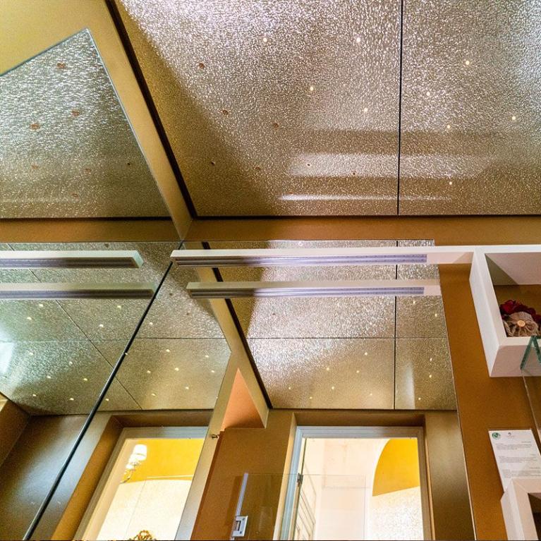 Modern bathroom with mirrored ceiling and LED lighting.