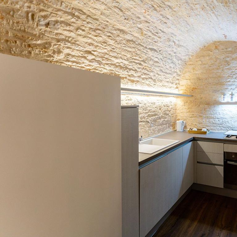 Cuisine moderne avec plafond voûté en briques et éclairage LED.