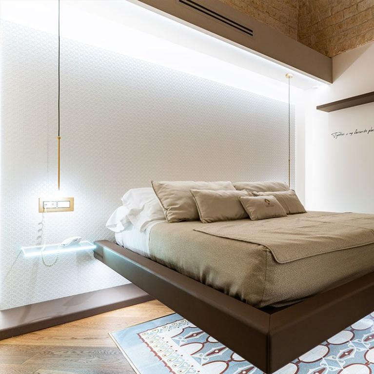 Camera moderna con letto sospeso e bagno in fondo.